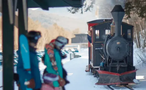 Family of Skiiers waiting for arriving trains at Loon